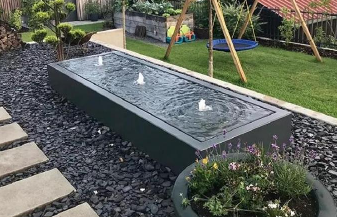 El polvo cubrió la fuente de agua de acero suave del rectángulo del jardín de la capa freática negra del metal