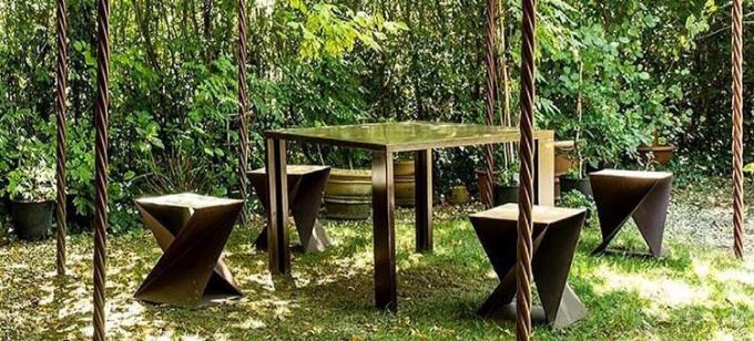 El sistema al aire libre de acero geométrico diseñado de los muebles de Corten incluye la tabla y taburetes